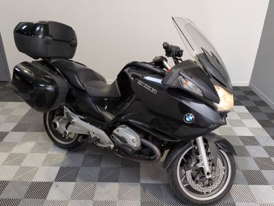 Une moto BMW garée sur un sol à damier dans un garage