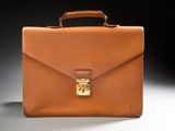a brown briefcase sitting on top of a table next to a black background