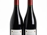 deux bouteilles de vin rouge posées l'une à côté de l'autre sur une surface blanche