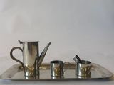 a silver tray with four cups and a teapot on it