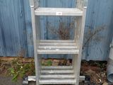 a ladder that is sitting on the ground next to a building
