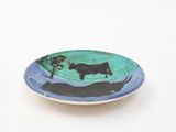 a plate with a cow on it sitting on a table