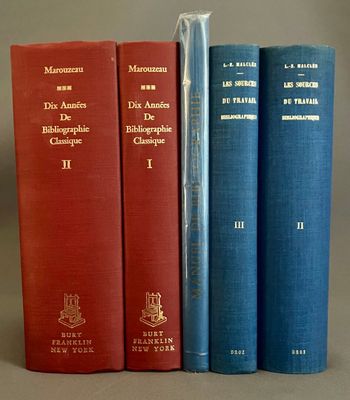trois livres sont alignés les uns à côté des autres sur une surface grise