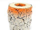 un vase blanc et orange dont la surface est craquelée