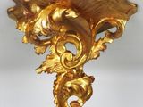 a gold wall sconce on a white wall