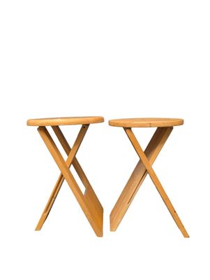 two wooden stools with crossed legs on a white background