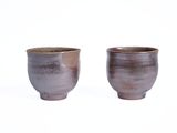 une paire de tasses marron et blanches sur fond blanc