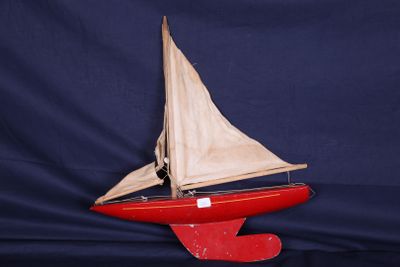 un voilier rouge avec une voile blanche sur fond bleu