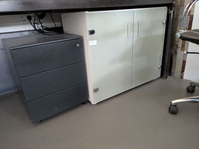 un bureau avec une armoire à dossiers et une chaise dans un coin