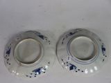 two blue and white vases sitting on a white table