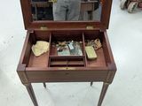 a man standing in a store looking at a small table with a mirror on it