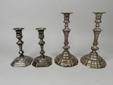 trois bougeoirs en argent posés les uns à côté des autres sur une table
