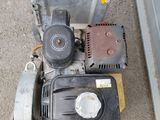 an image of a gas powered lawn mower sitting on the side of the road