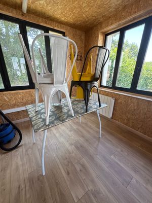deux chaises et une table dans une pièce dotée de fenêtres