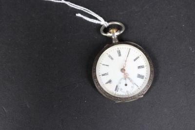 une montre de poche suspendue à un cordon sur une surface noire