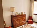 un salon avec un canapé, un fauteuil, une table et une fenêtre