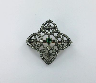 un gros plan d'une broche sertie d'une pierre verte
