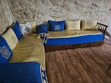 a couch with blue and yellow pillows on it in a room