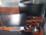 two monitors and a laptop sitting on a desk