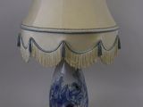 une lampe bleue et blanche munie d'un abat-jour blanc