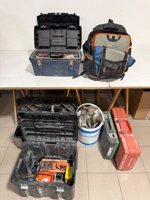 de nombreux outils dans la mallette posée par terre à côté de la table
