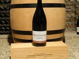 une bouteille de vin posée à côté d'un tonneau de vin