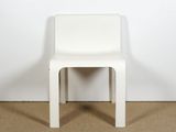 a white plastic chair sitting on top of a carpeted floor