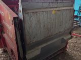 a red dumpster sitting in the middle of a pile of hay