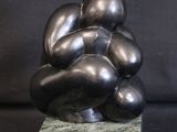 a sculpture of a bunch of black balls on a marble base