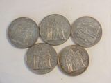 six different types of coins sitting on top of a white surface