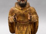 statue of a man with a beard and a robe holding his hands up