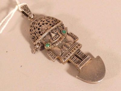 a silver pendant that has a small building on it