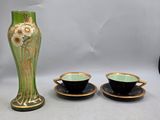 two cups and a vase sitting on a table