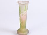 a glass vase that has a green and pink design on it