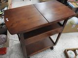 une table en bois surmontée de deux étagères, placée au milieu d'une pièce