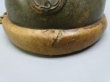 a close up of a metal bowl on a wooden stand
