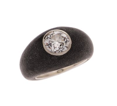 une image représentant une bague ornée d'un diamant posé sur une pierre noire