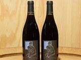 deux bouteilles de vin posées sur un tonneau