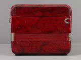 a red piece of luggage sitting on a white surface