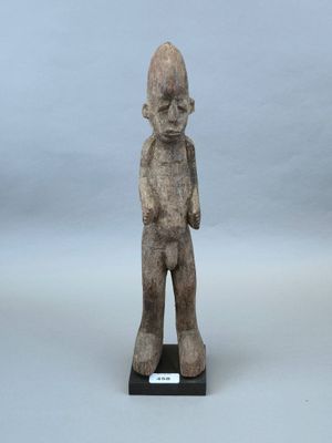 une image représentant une statue d'un homme debout sur un socle en bois