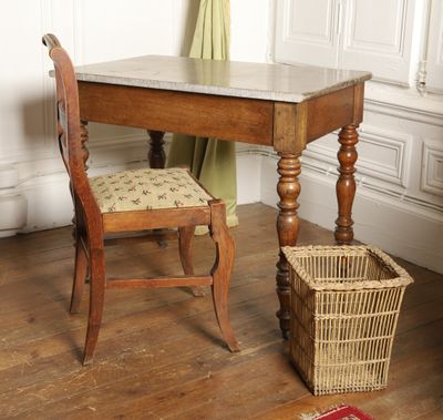 a small table with a chair and a basket on the floor