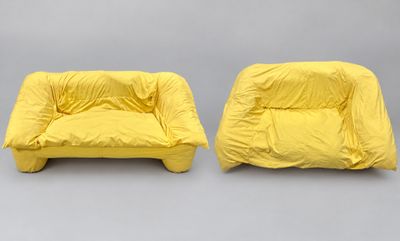 two yellow chairs with covers on them sitting next to each other