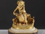 une image représentant une statue en or d'un enfant assis sur un rocher