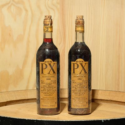 two bottles of wine sitting on top of a barrel