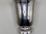 a silver vase on a white table with a white background
