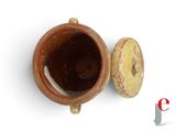 a brown cup with a lid sitting on a white surface