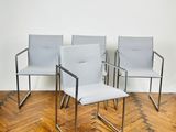 trois chaises dans une pièce avec un parquet et un mur blanc