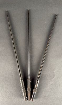 two metal tonges on a gray surface with a white background
