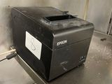 a black printer sitting on a metal counter in a kitchen