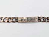 une photo en gros plan d'un bracelet en argent posé sur une surface blanche